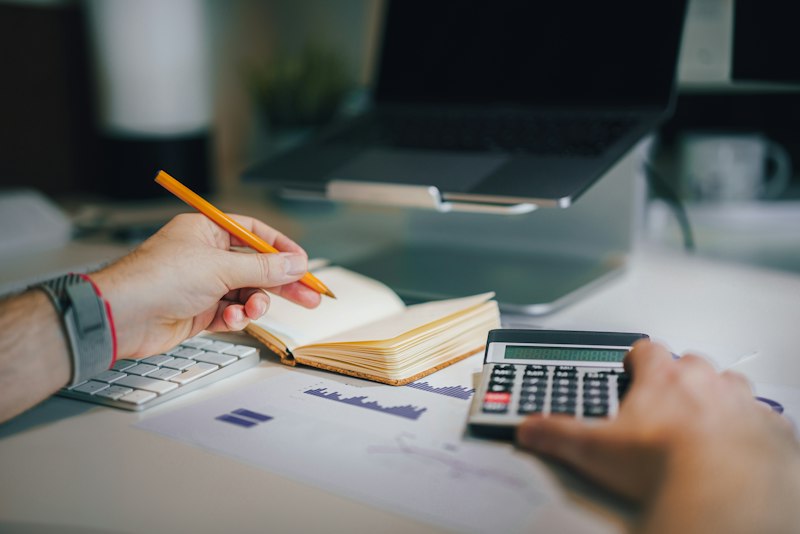 A bookkeeper working with a calculator and notebook